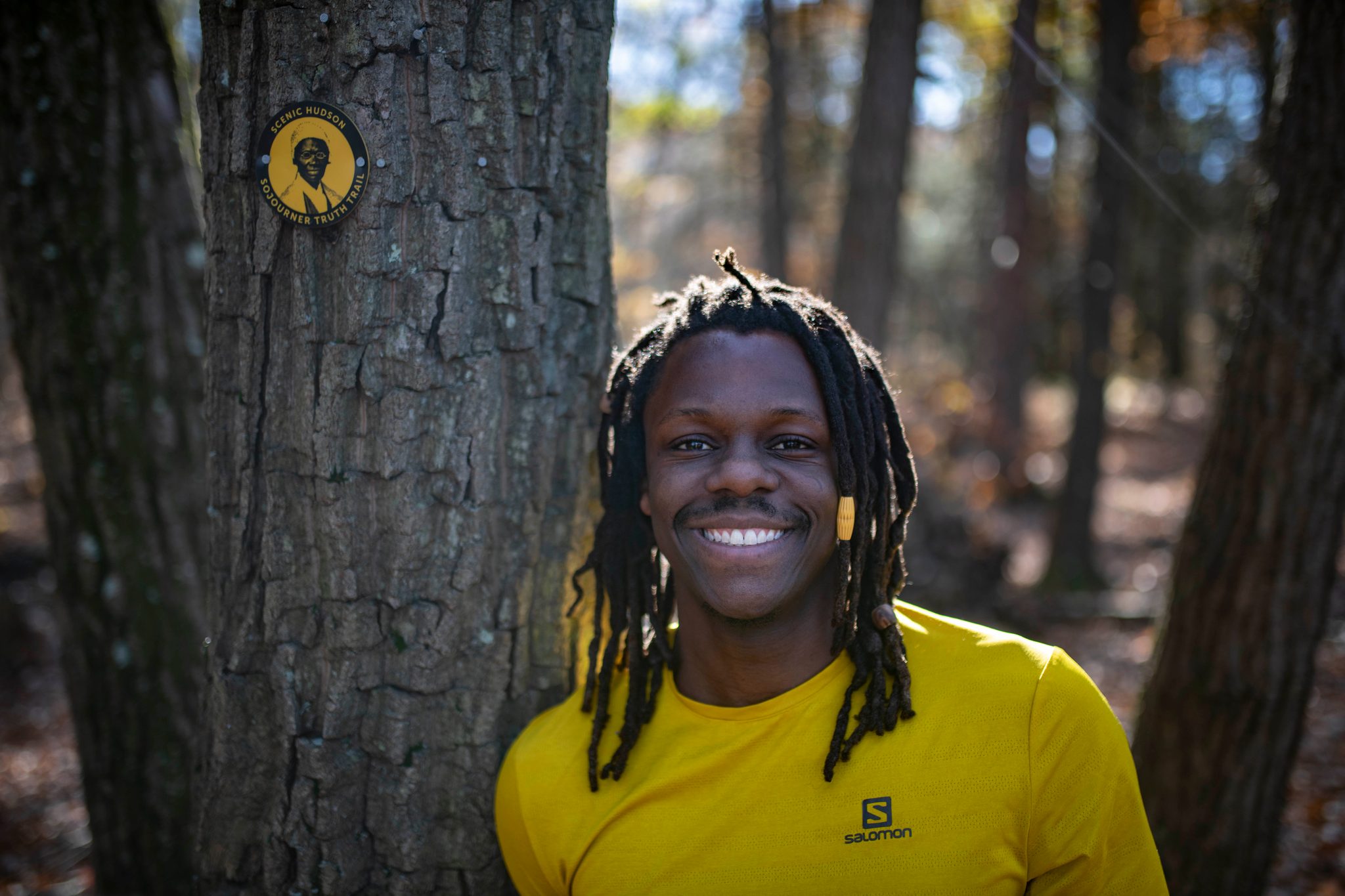 A wide grin beside a trail-marked tree.