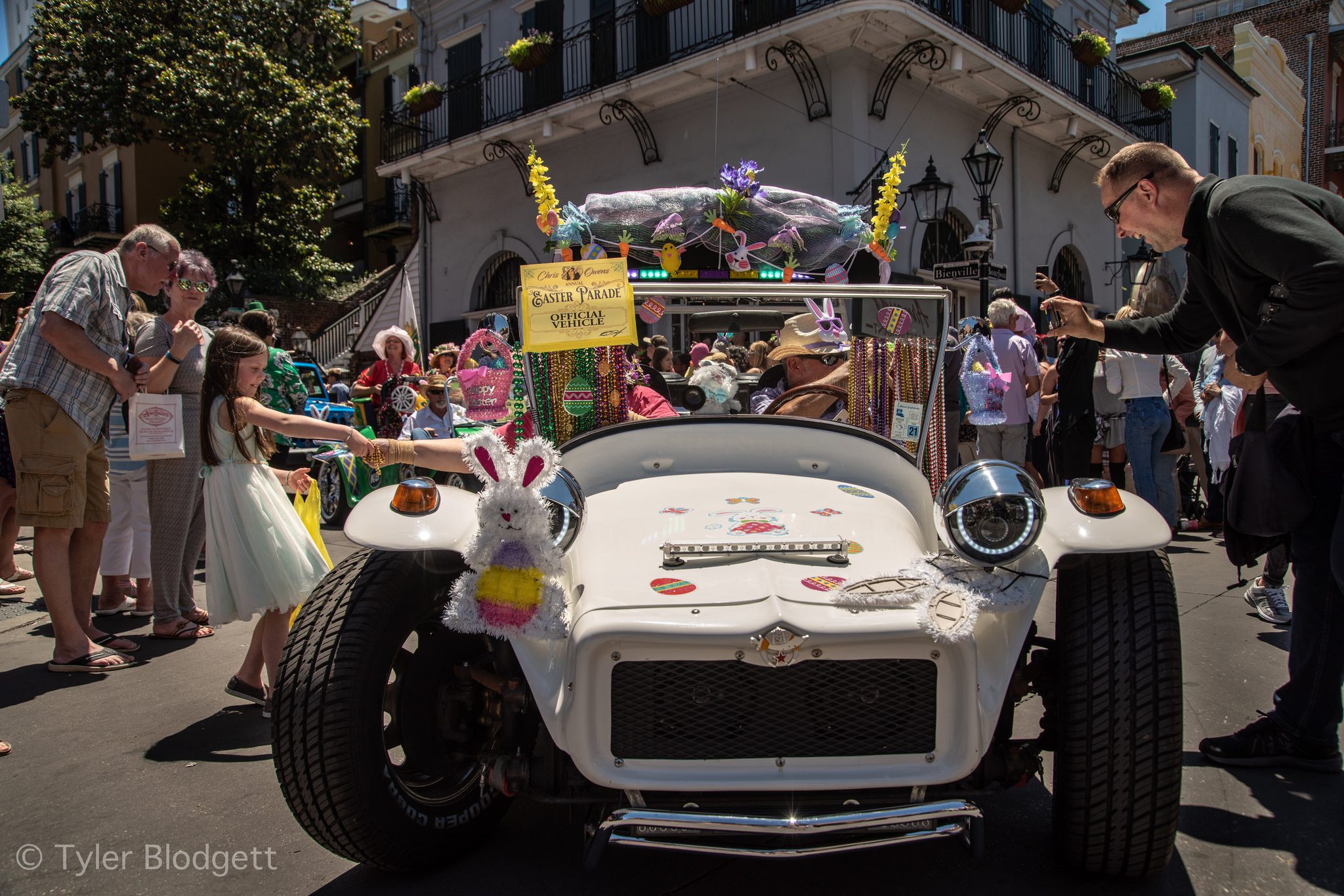 Bunny ears ride the hood of the lead car as it inches through the Easter crowd.