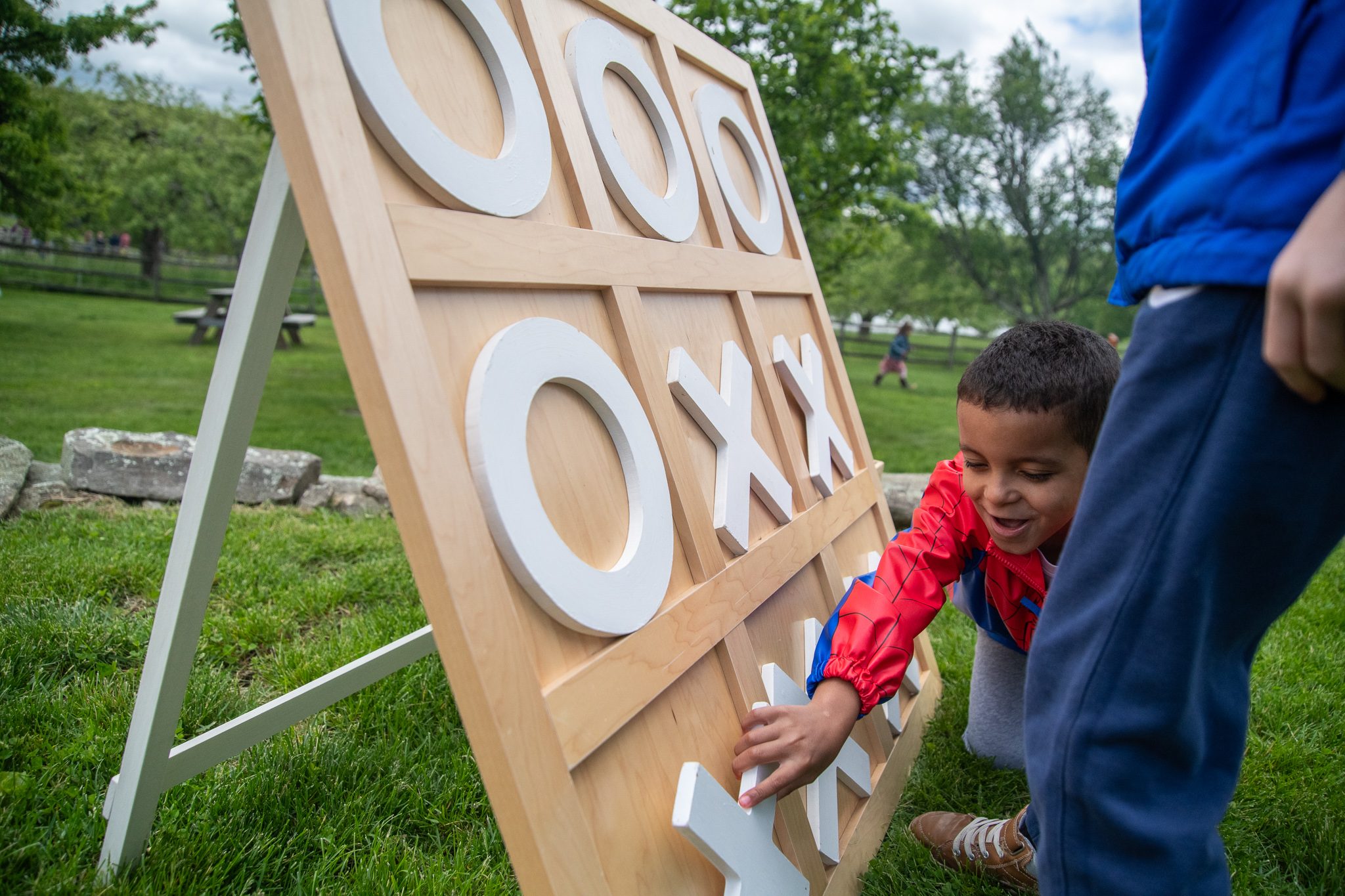A boy grins as he places his X on the giant tic-tac-toe board.
