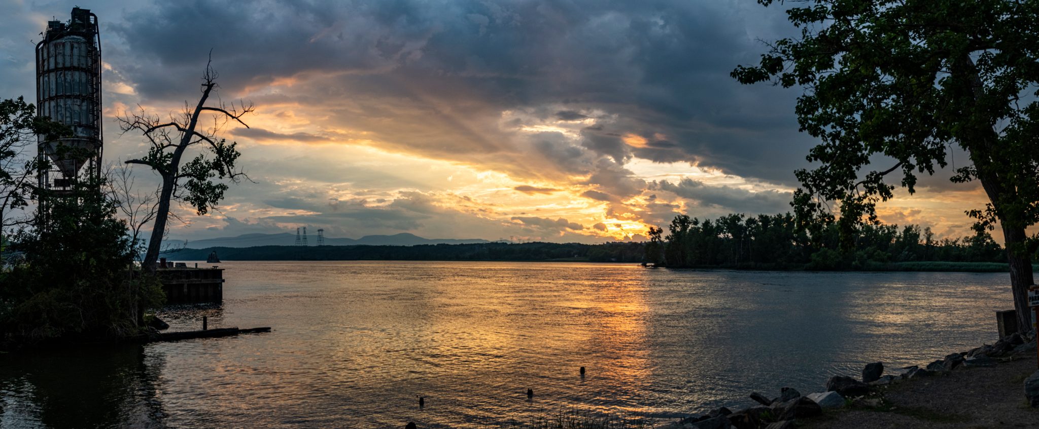 Sunset through broken cloud over the river.