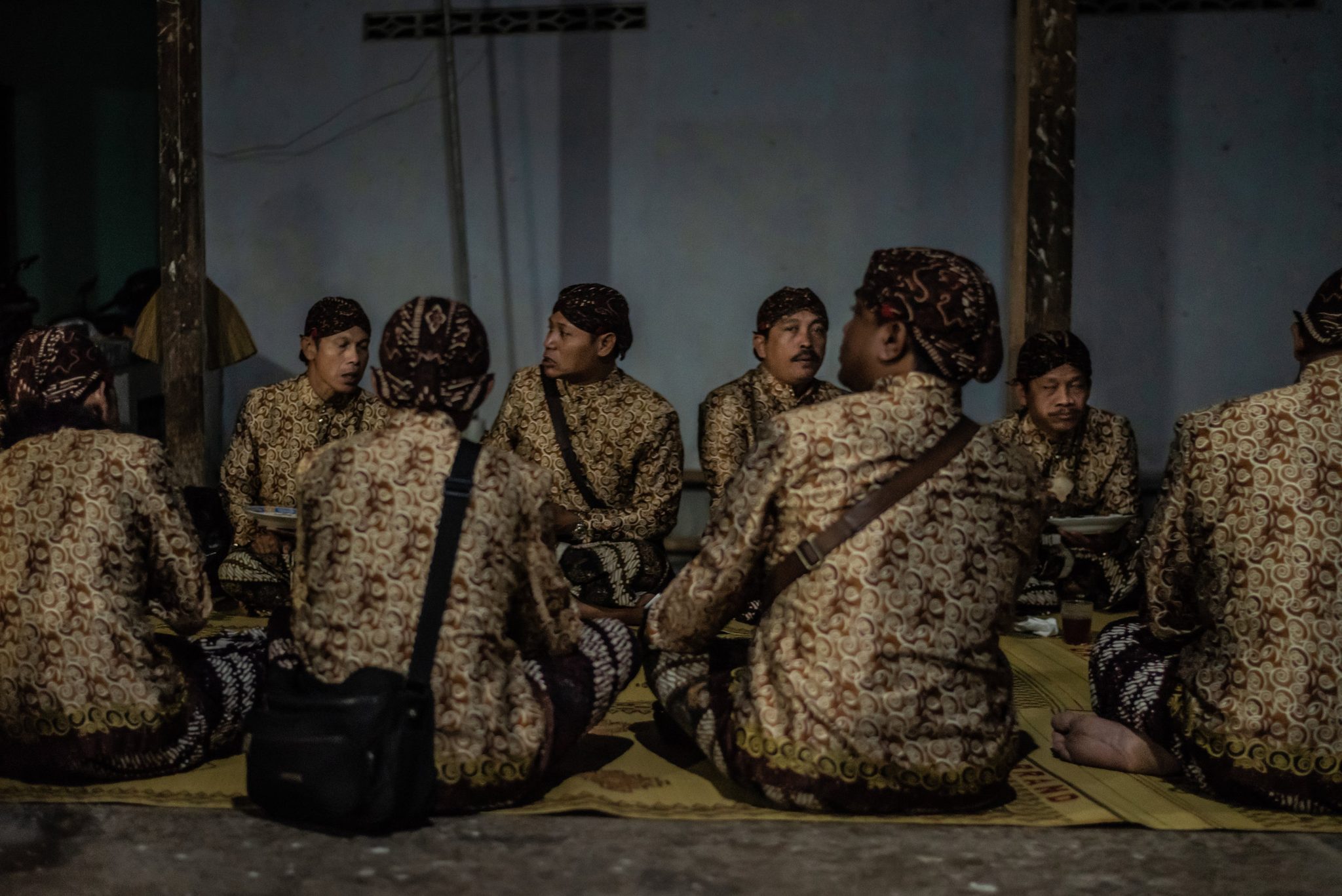 Members of the gamelan orchestra converse and eat before the show