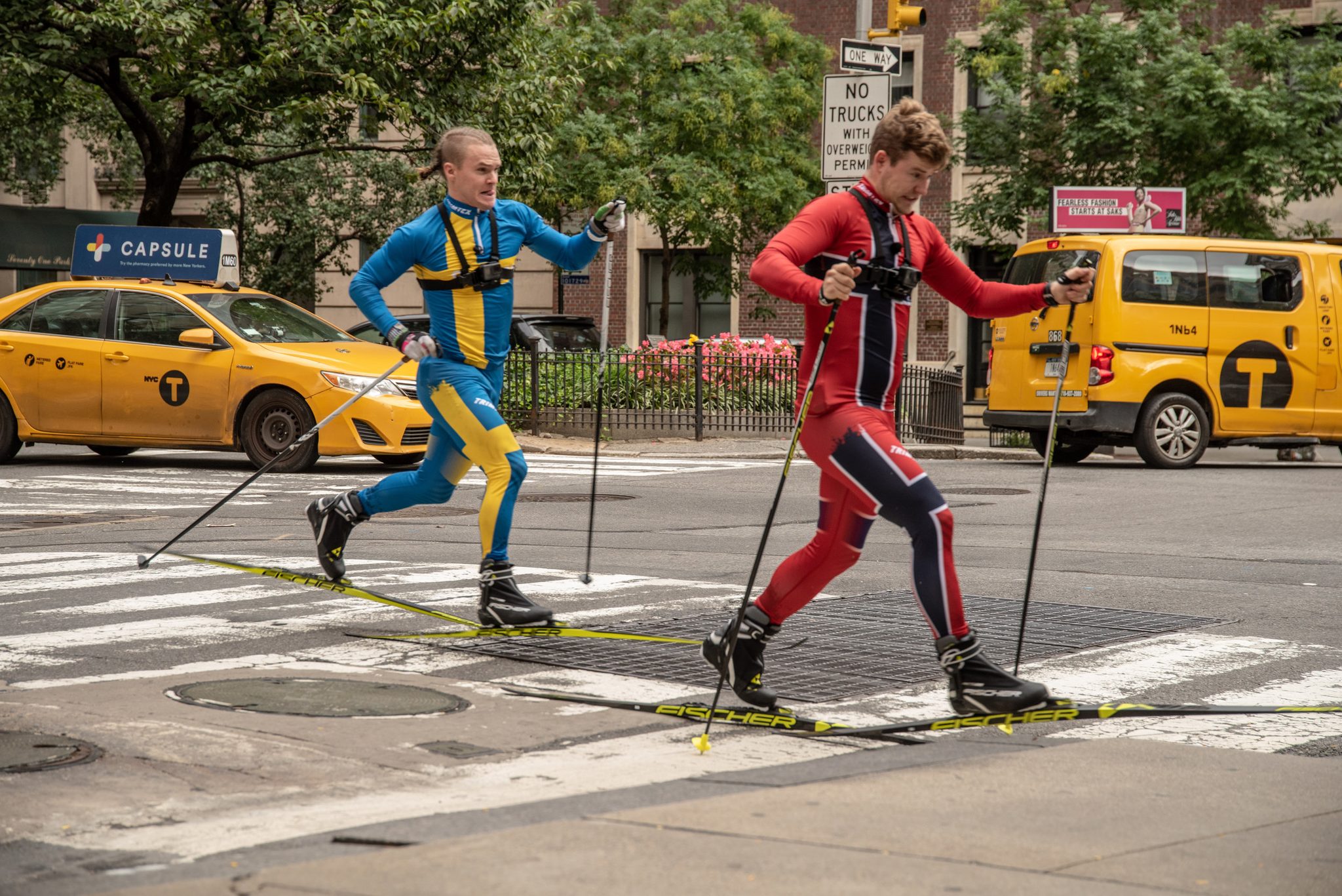 Two men in racing suits cross-country ski over the crosswalk, no snow required.