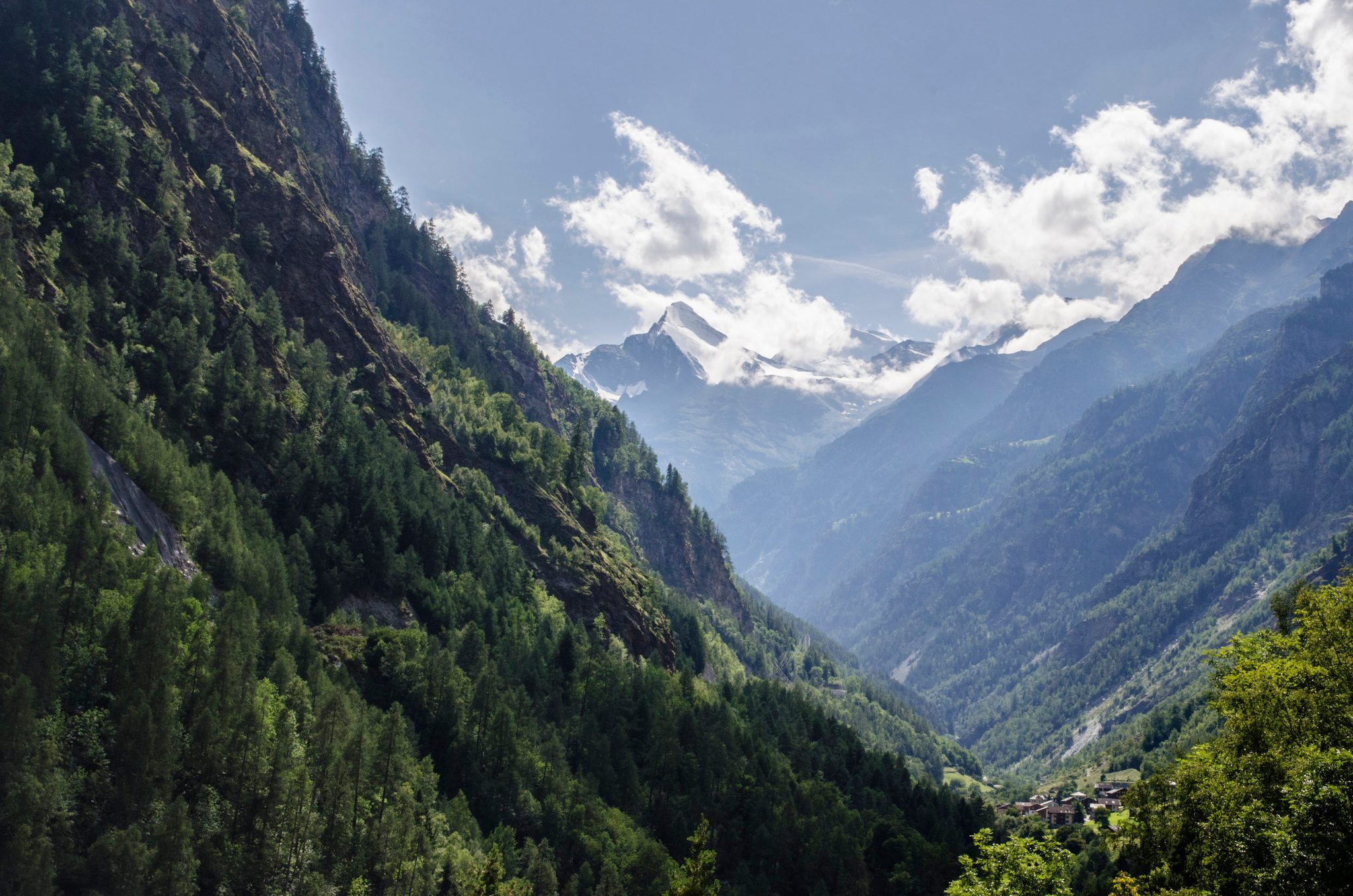 The valley opens toward Zermatt, clouds snagged on the peaks ahead.