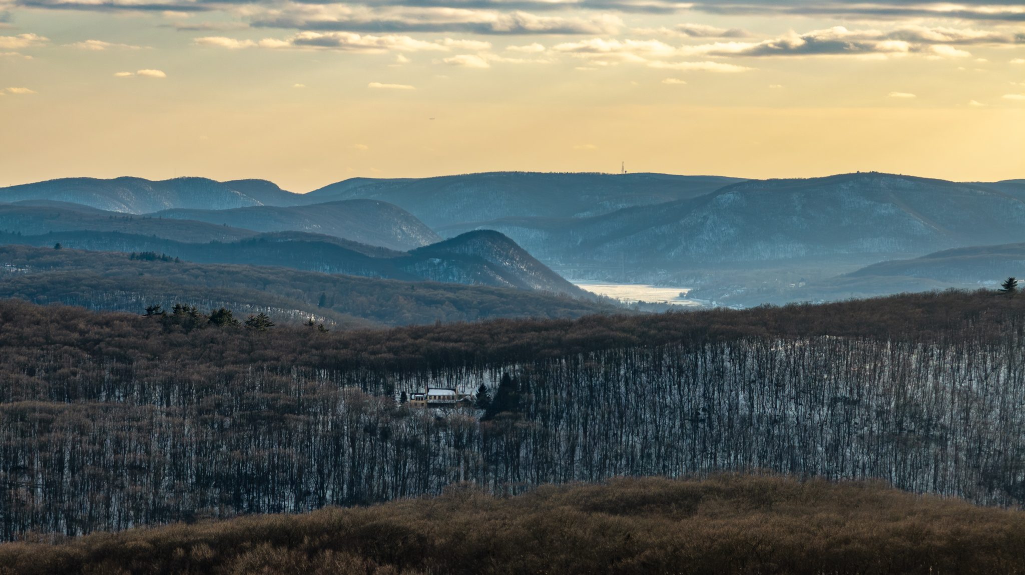 Late light over layered ridges, a river glinting in the gap.
