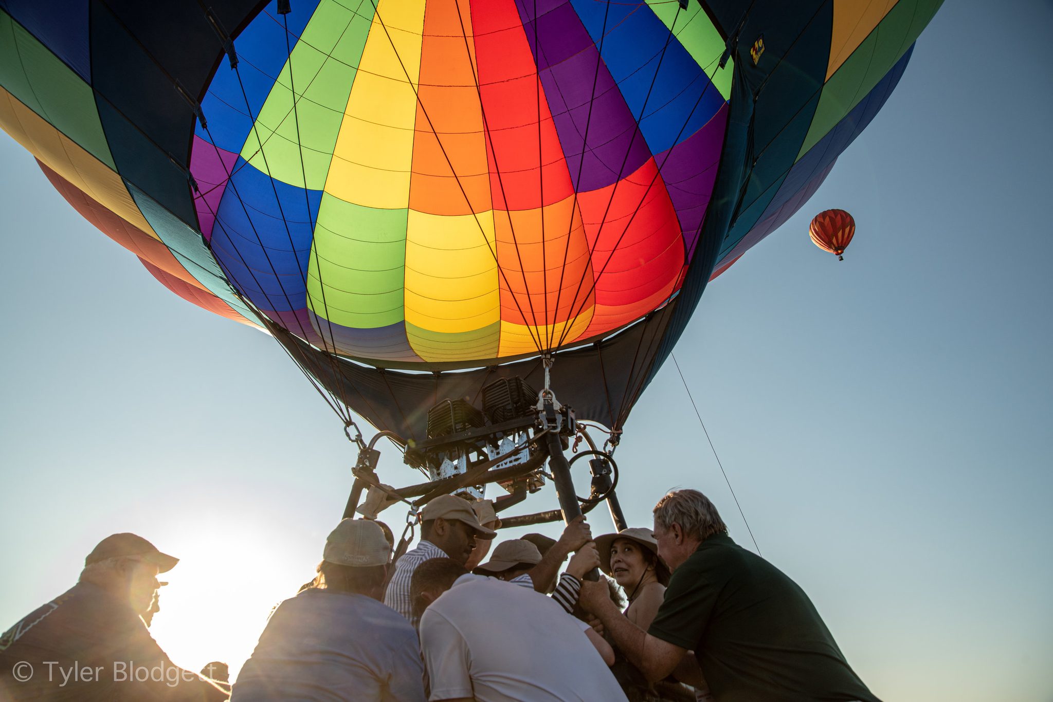 The rainbow balloon lifts off over the crew's heads, another already high in the sky.