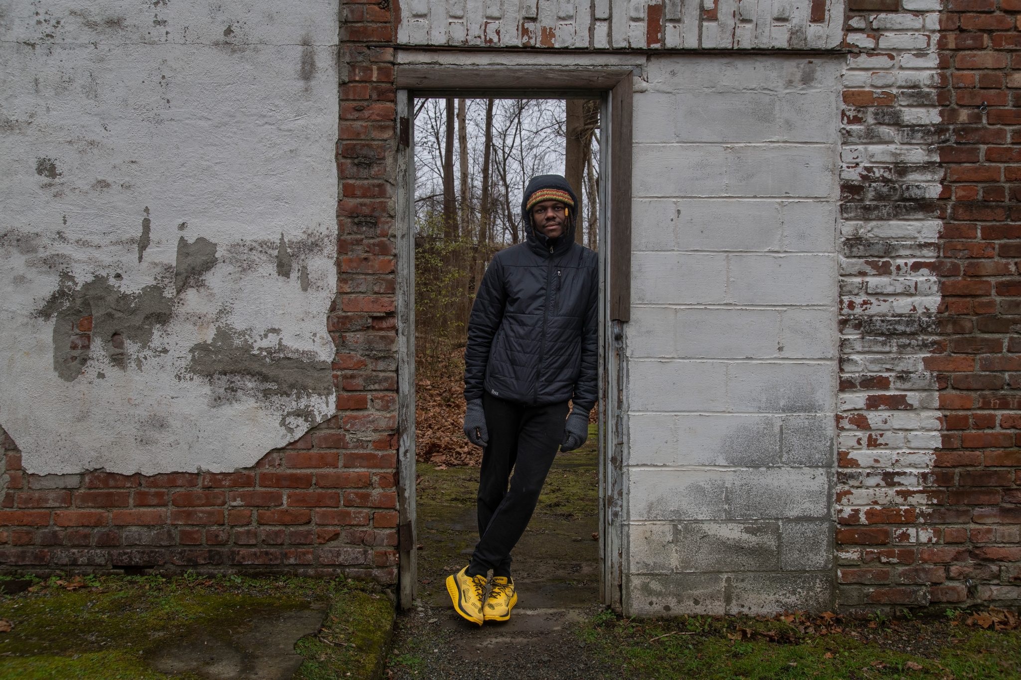 Chev leans in the doorway of a crumbling brick ruin, peeling whitewash on both sides.