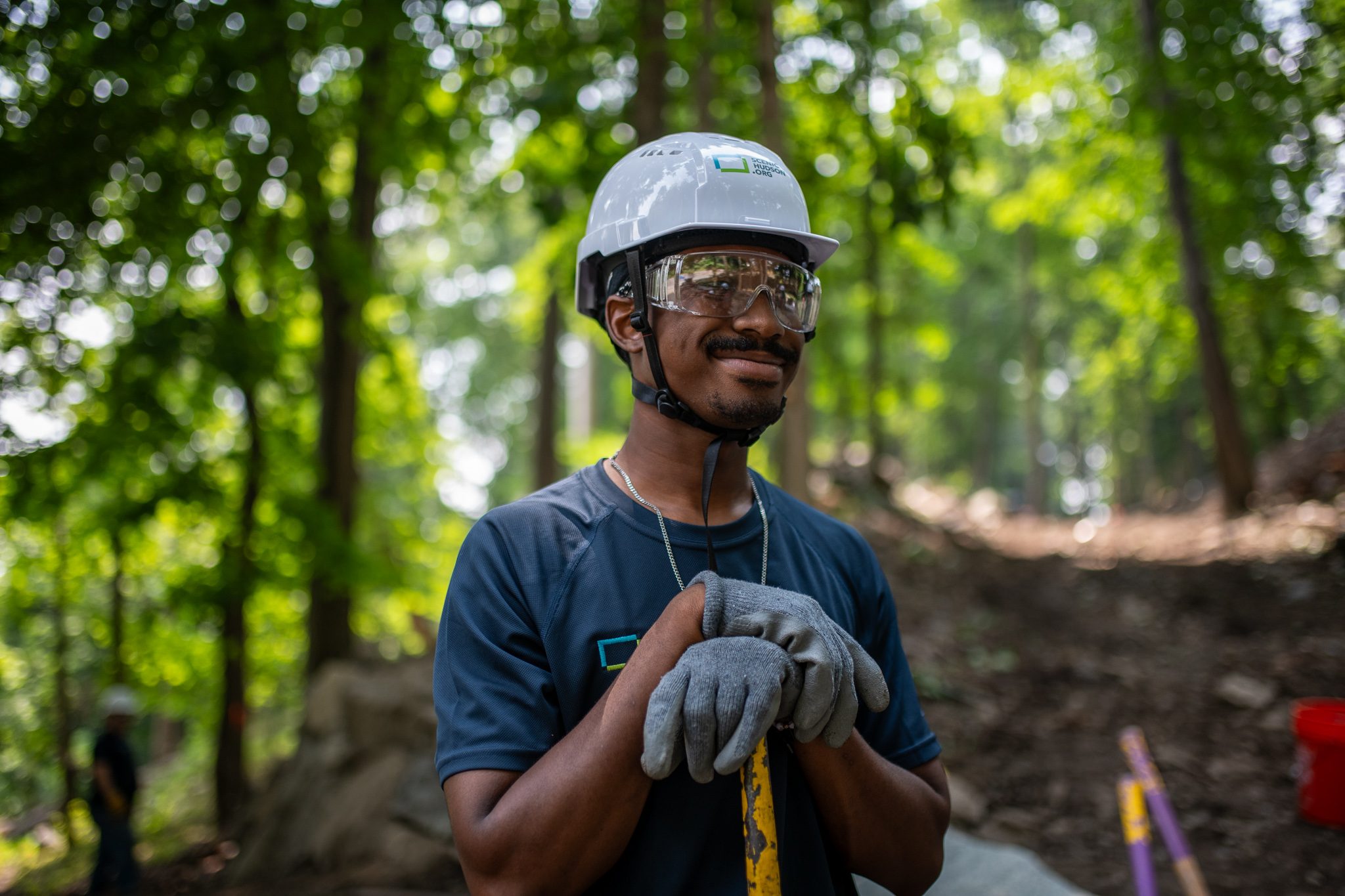 The same smile, the forest bright behind him.