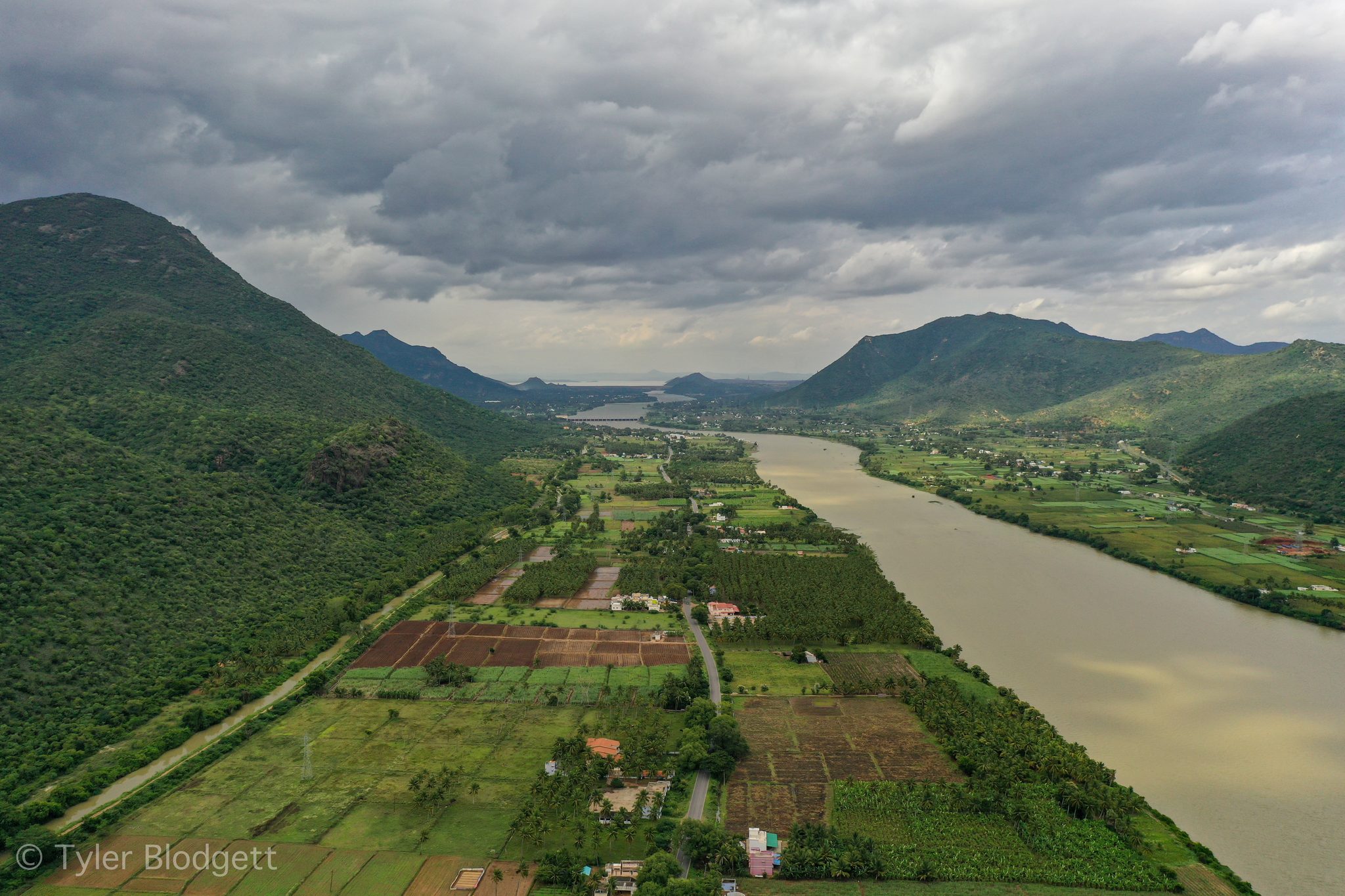 The river winds between green hills and patchwork fields.