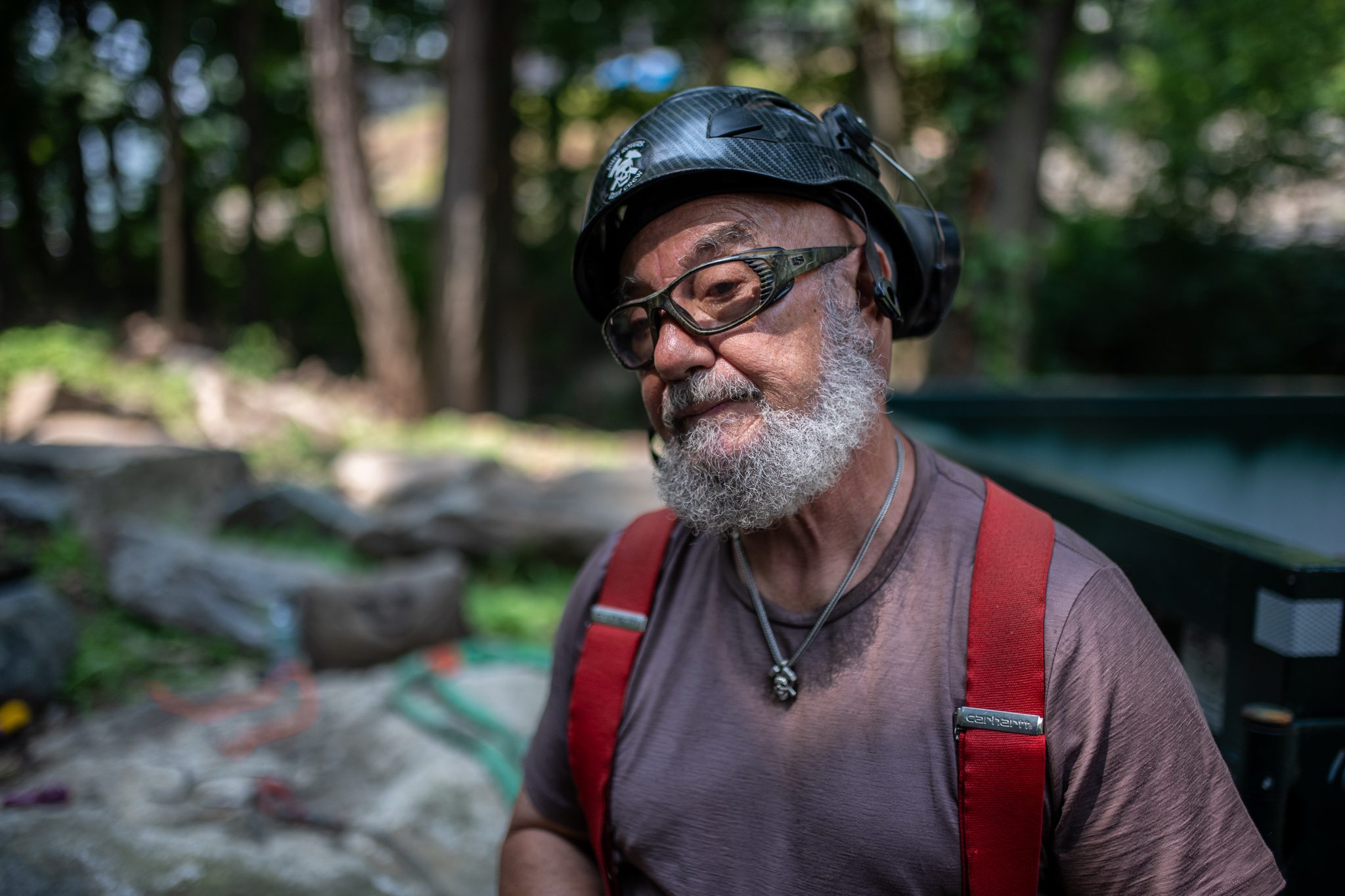 The crew leader smiles, hearing protection on and dust in his beard.