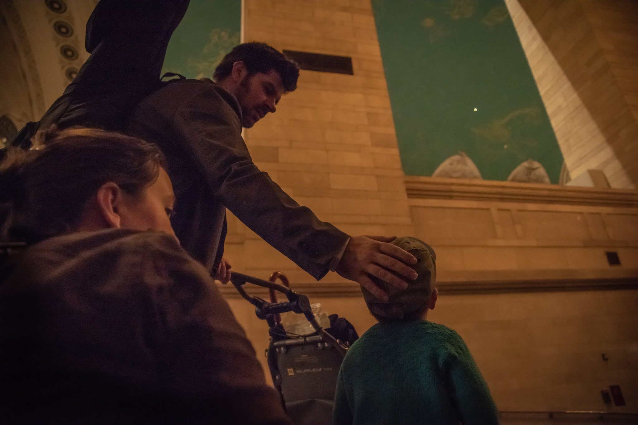 Emmet rests a hand on Ronin's head as they come up into Grand Central.