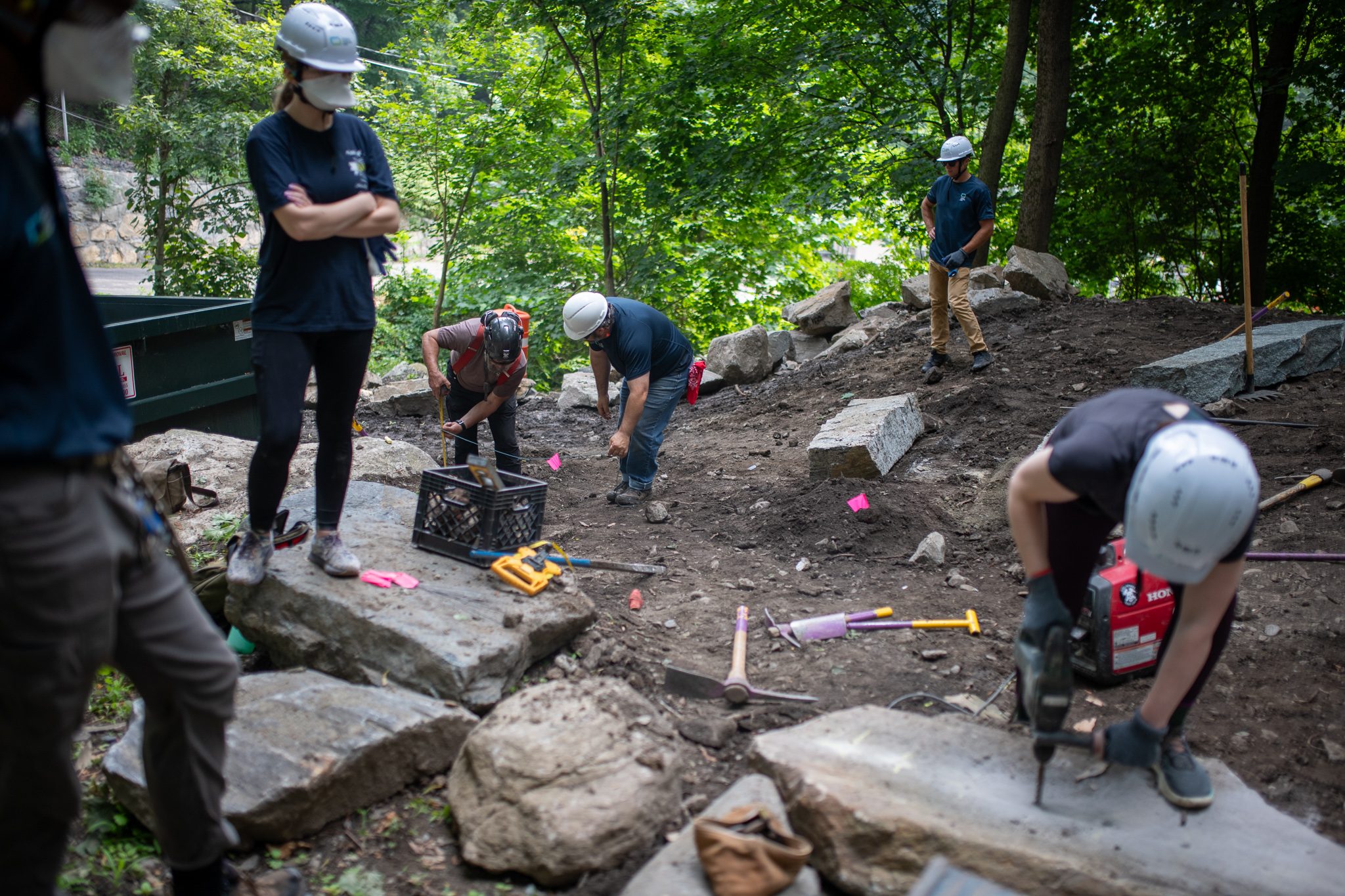 Across the slope, the crew drills and splits stone for the next steps.