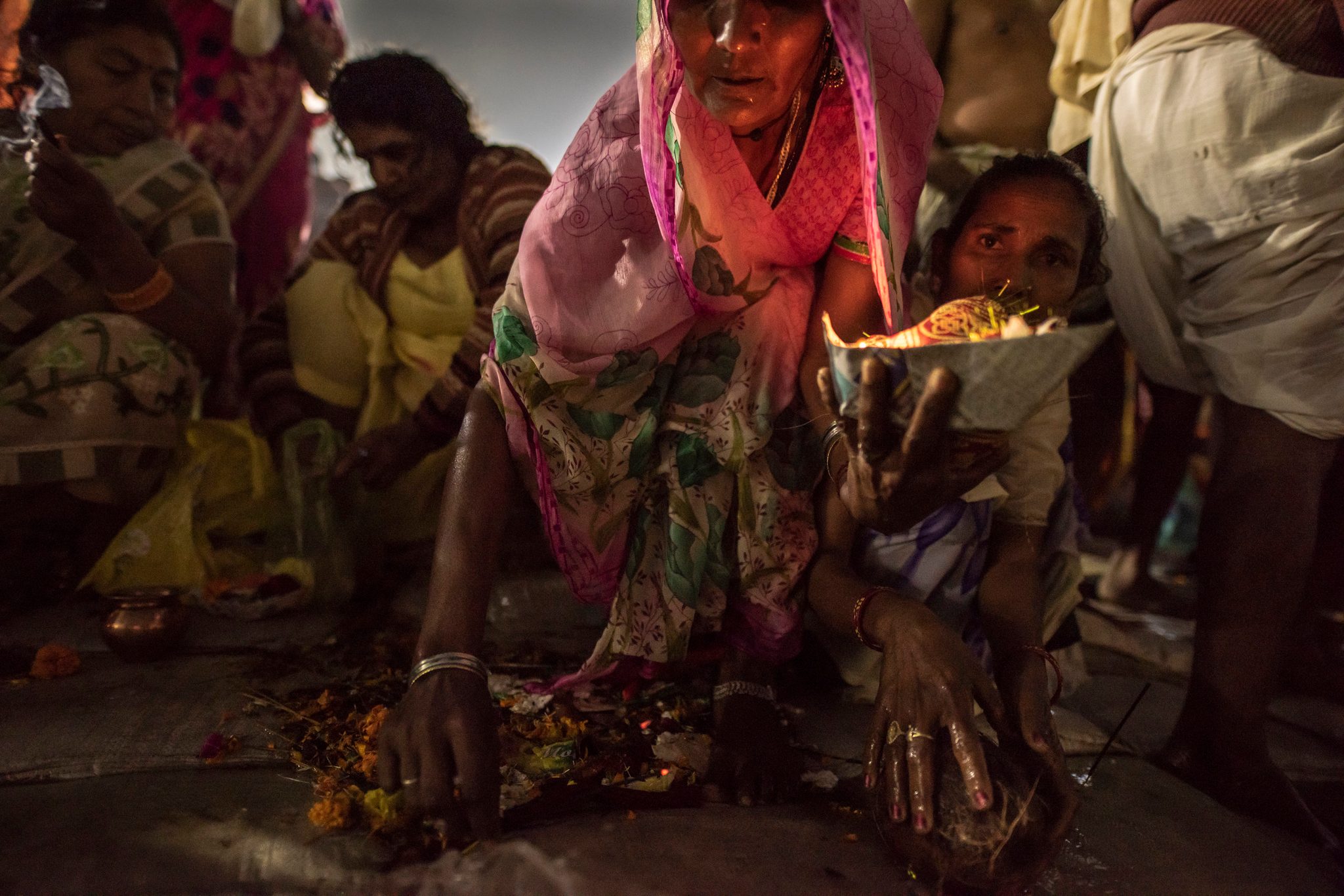 Women push through the throng to pray and offer fruit and flowers as pooja