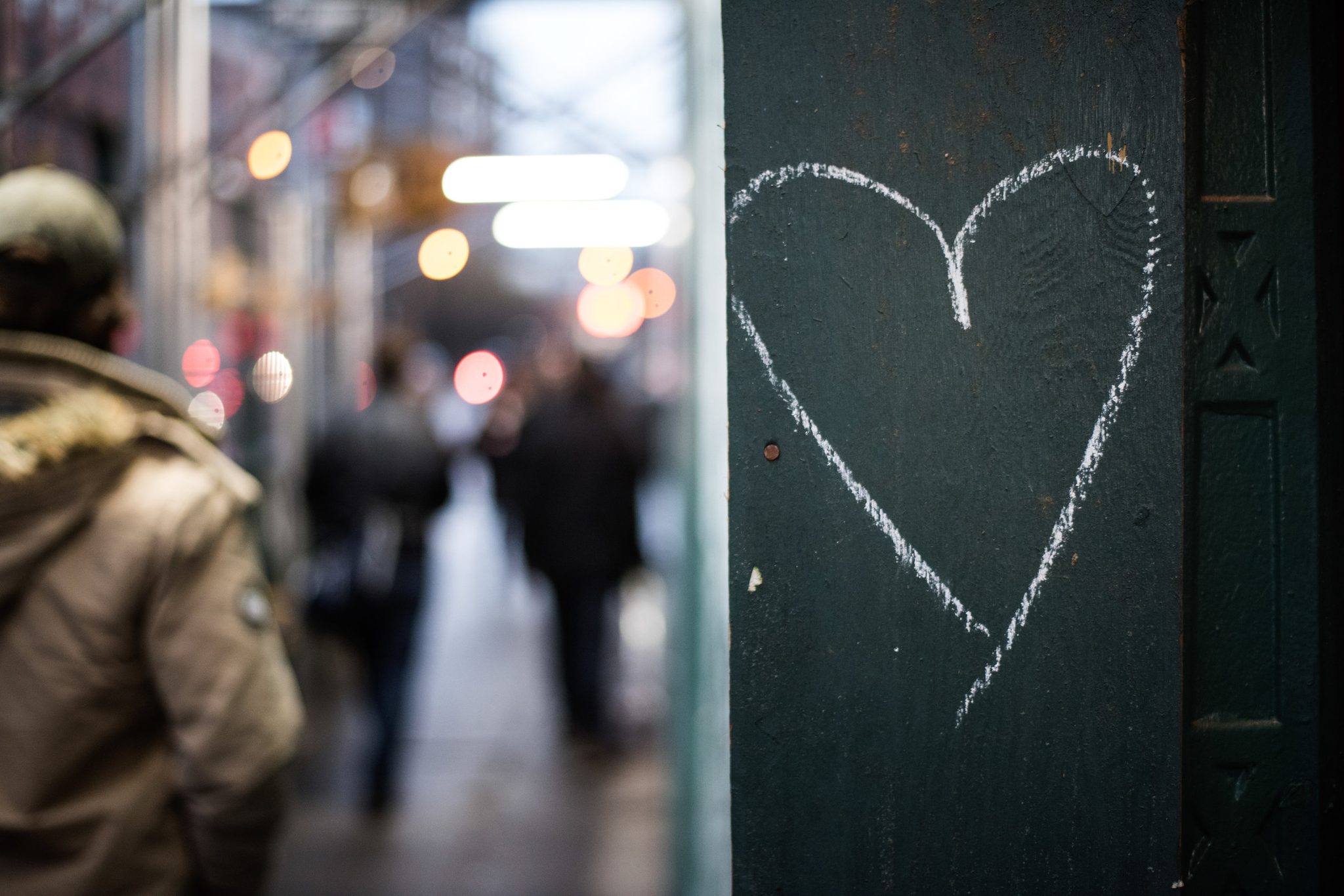Someone chalked a heart on the pillar, and the city walks right by.
