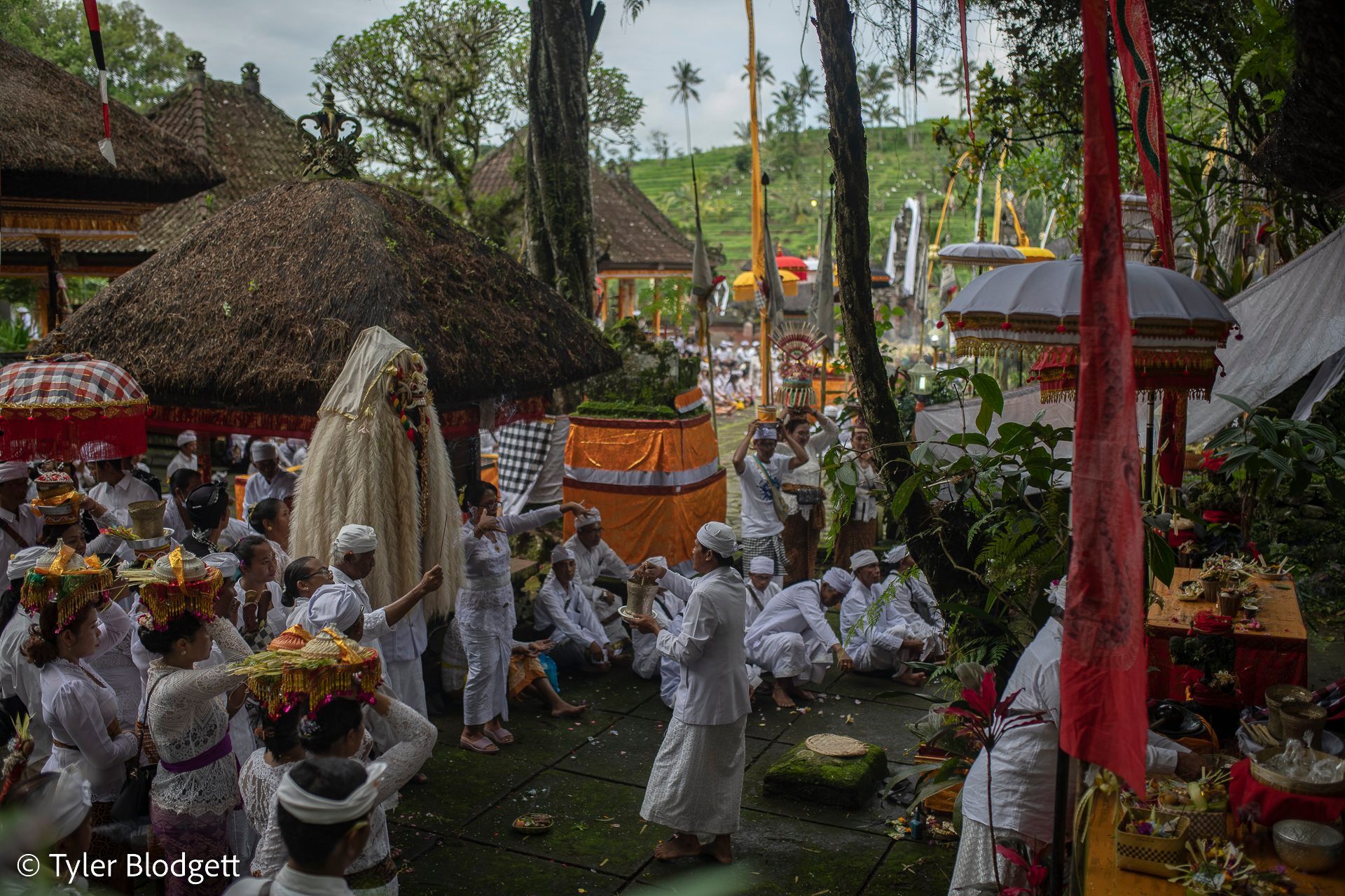 Under the thatched shrines of Pura Luhur Besikalung, the courtyard fills with offerings and white.