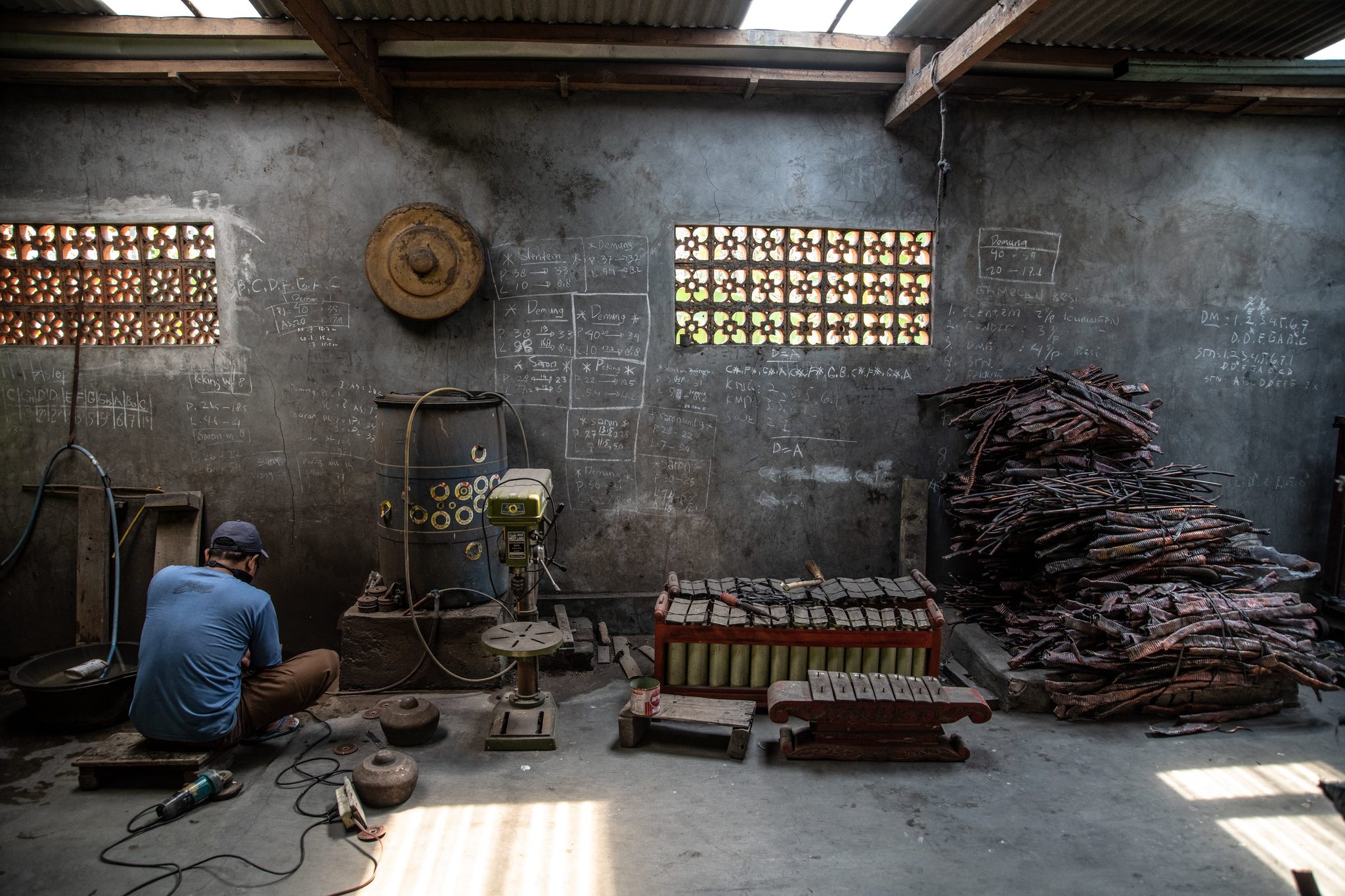 Gamelan maker works machine to polish smaller gongs