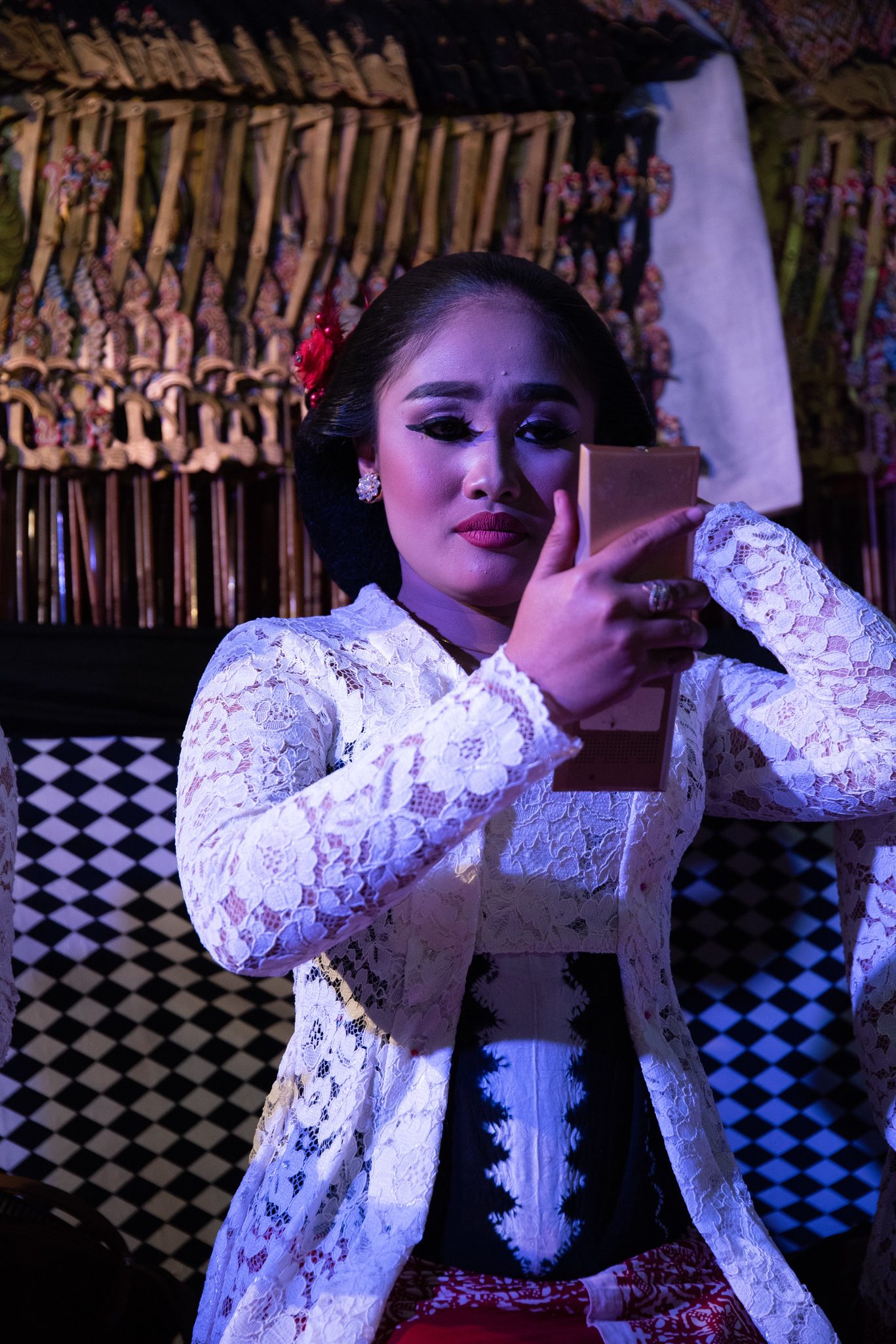 A singer takes a selfie in front of the rows of puppets.