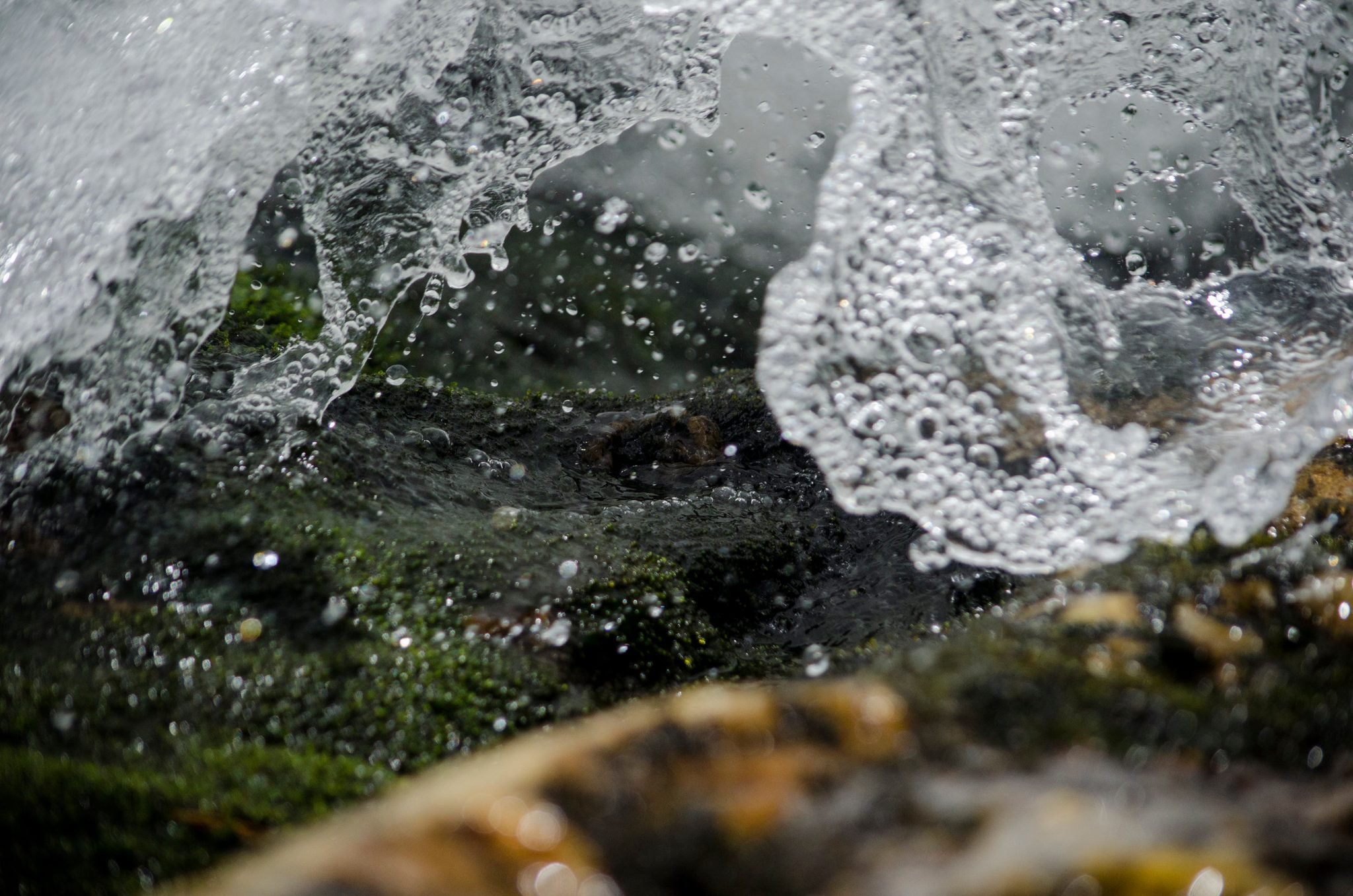 Water folds over mossy stone, frozen by the shutter at Hamilton Falls.