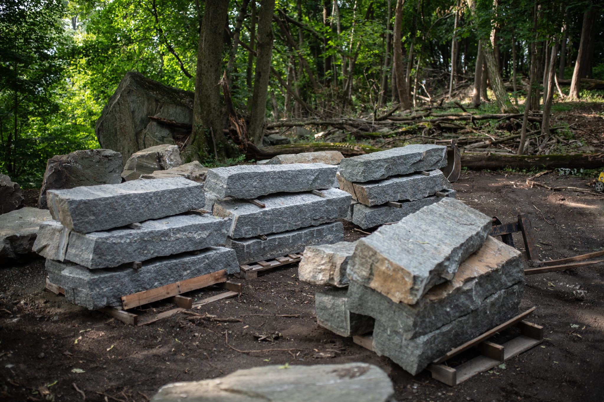 Granite blocks wait on their pallets, stacked and ready to become steps.