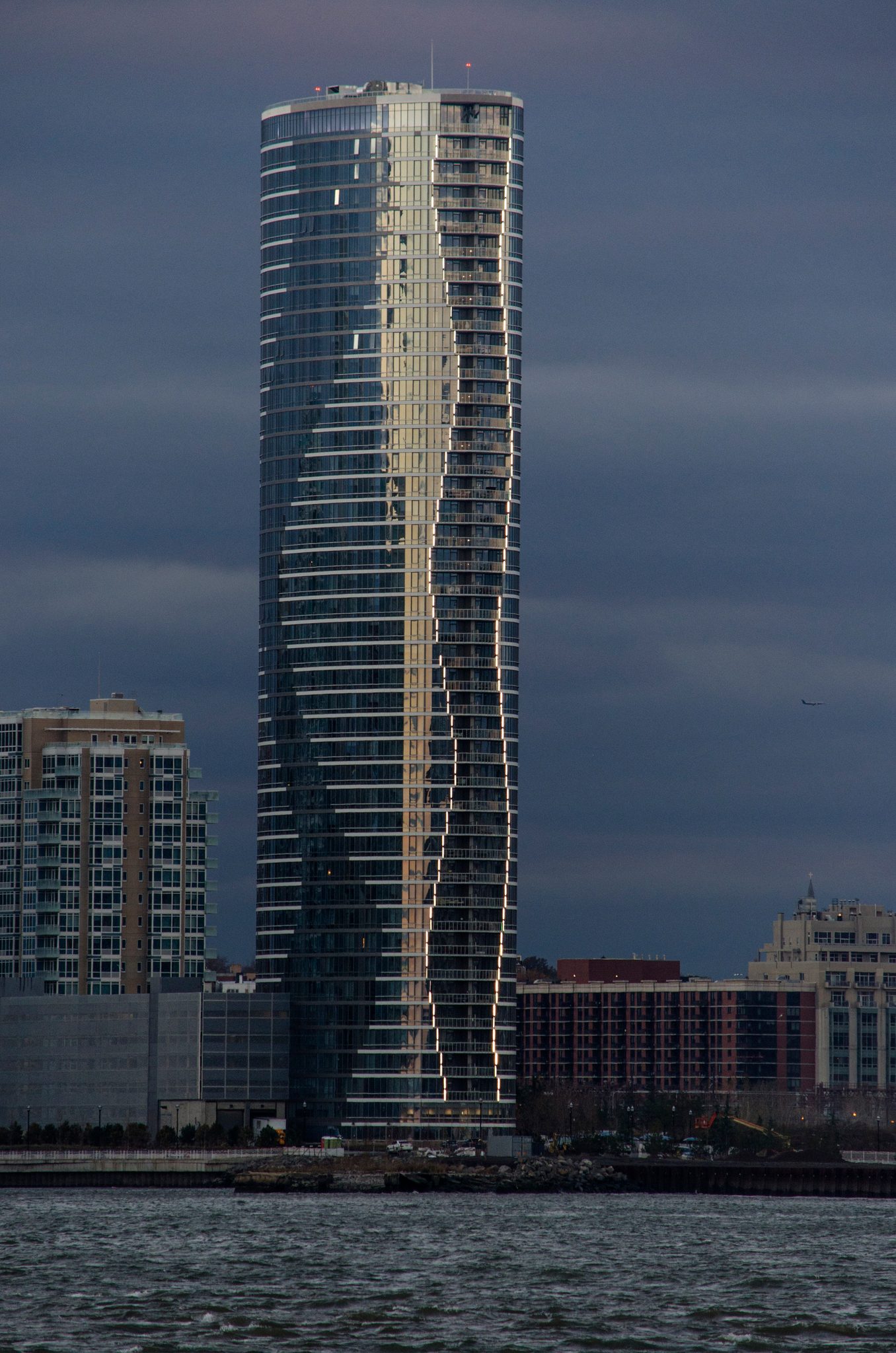 Across the river, a single tower twists up into the dusk.